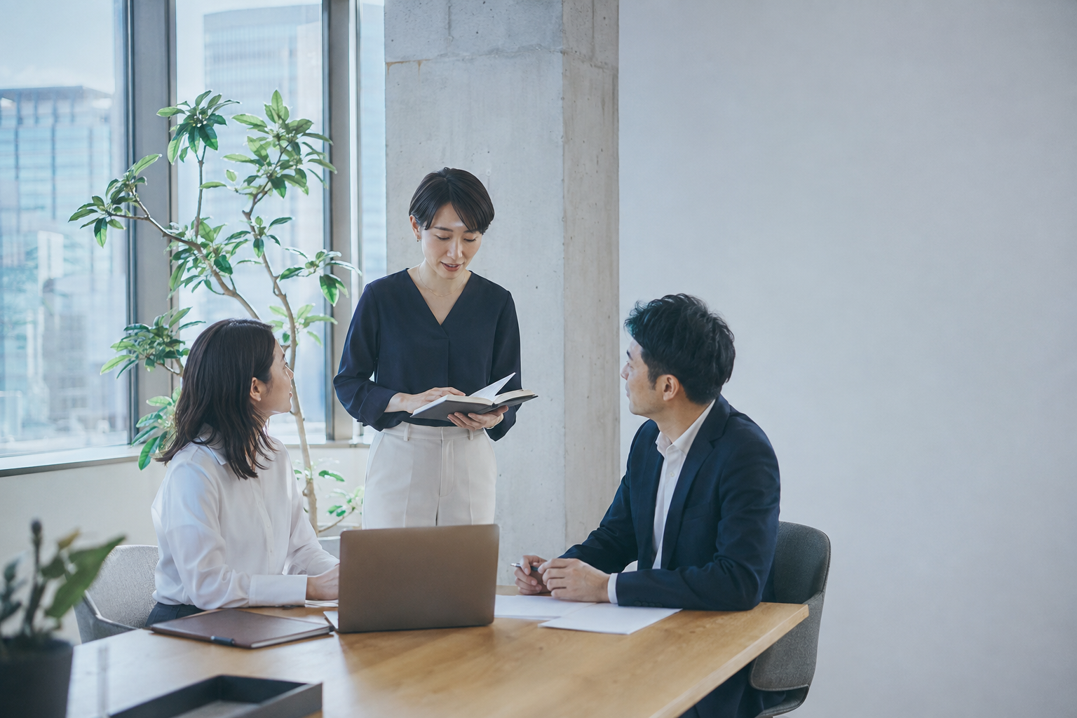 明るいオフィスで自然に打ち合わせをする3人